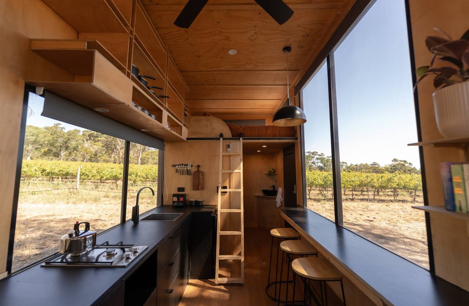 Built in table next to large window in tiny house with loft