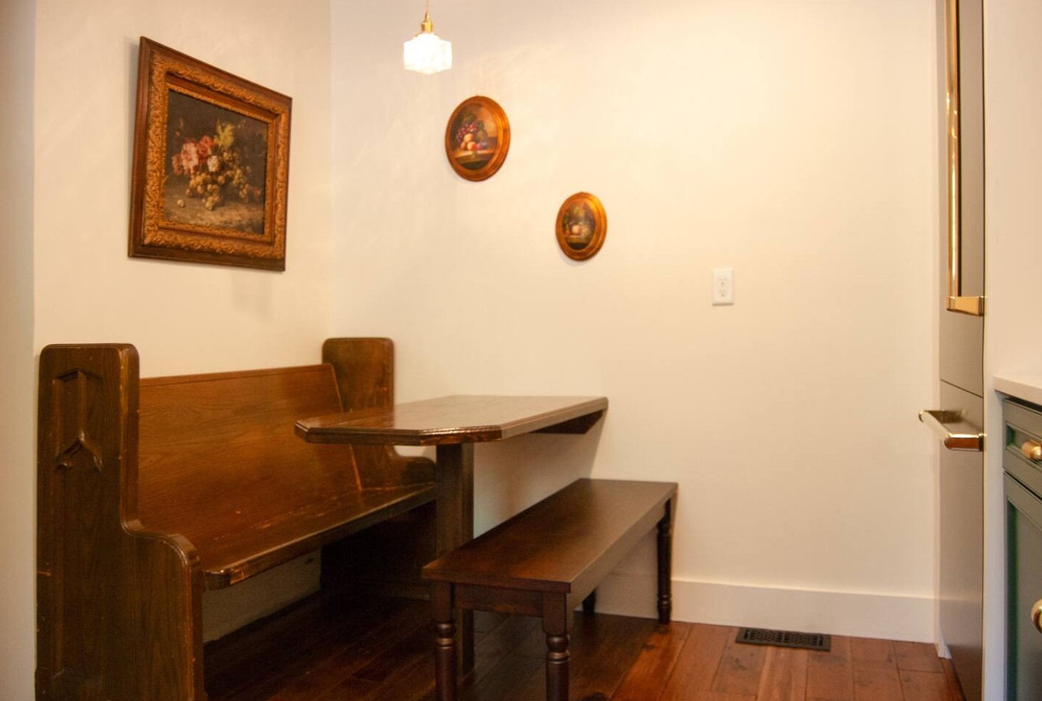 Dining area with a wooden booth and paintings