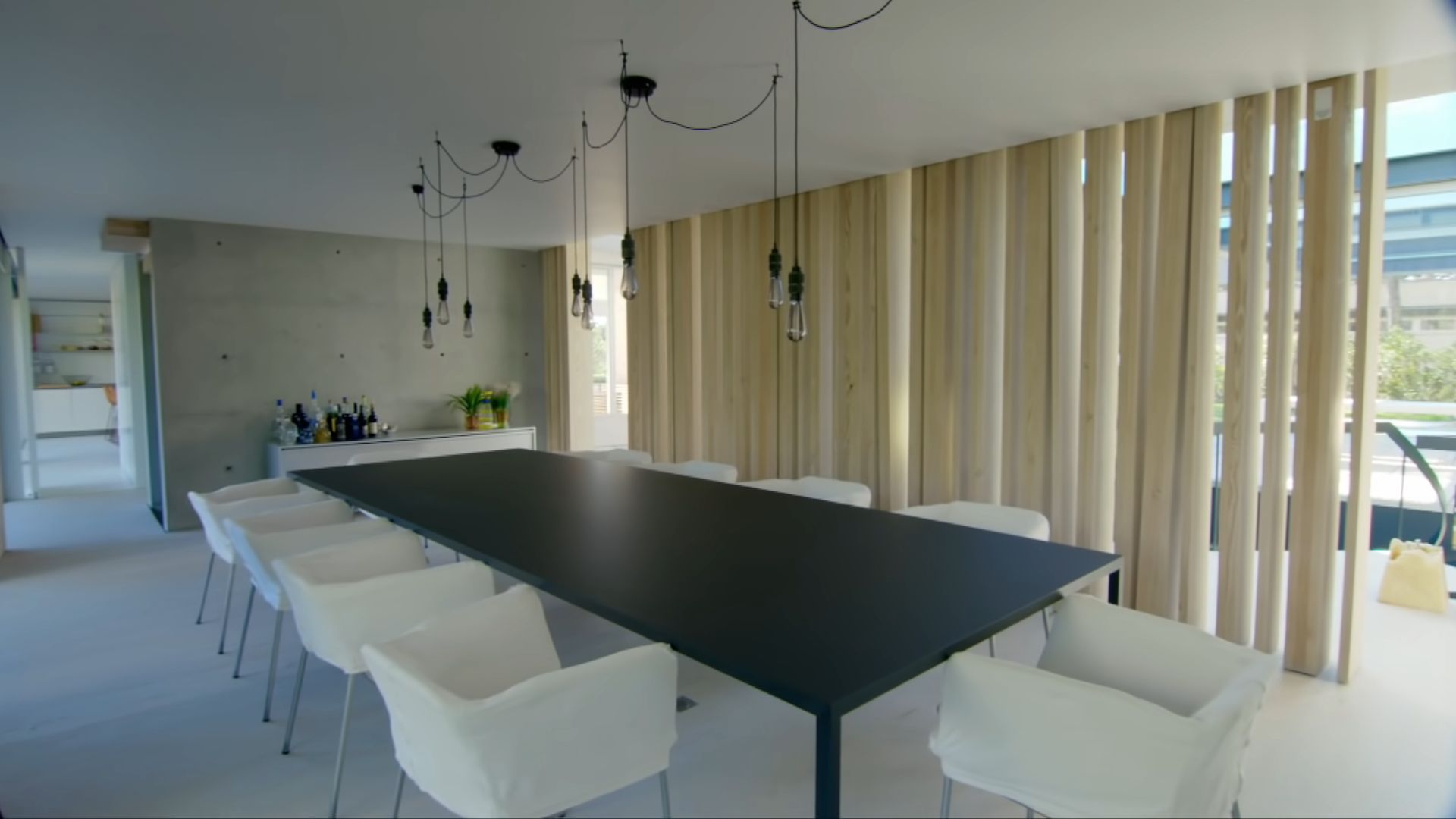 Dining room with a huge table and a wooden backsplash