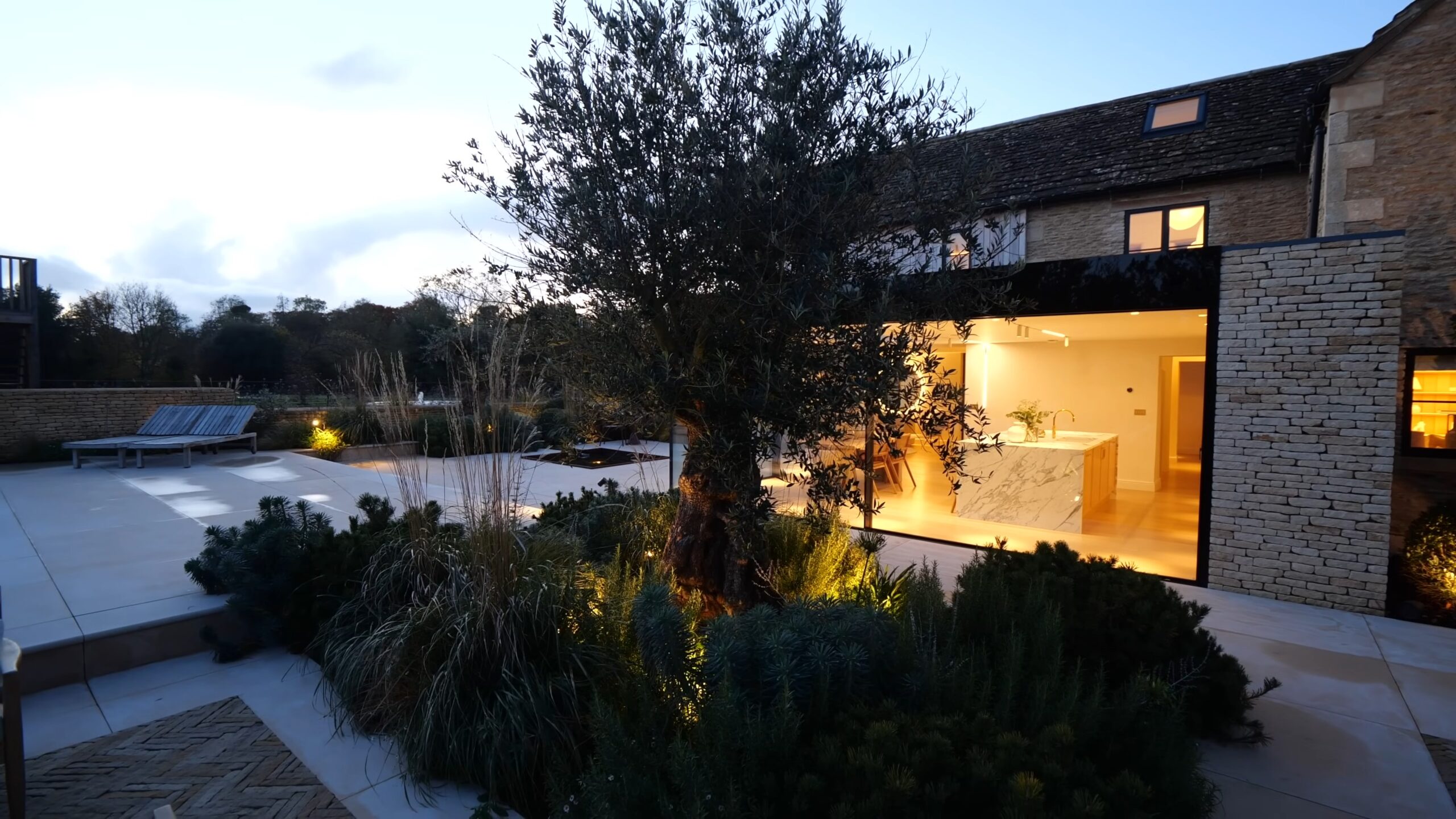 Exterior of a modern county home with a lit up tree