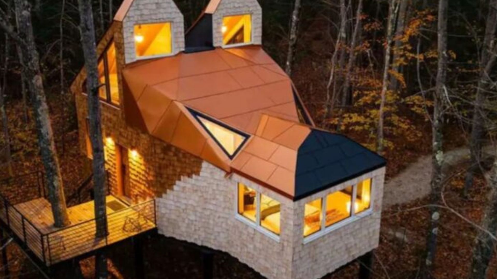 unusual treehouse shaped like a fox head with same colors as the fox, copper roof, and ears, windows strategically placed to remind of a real animal