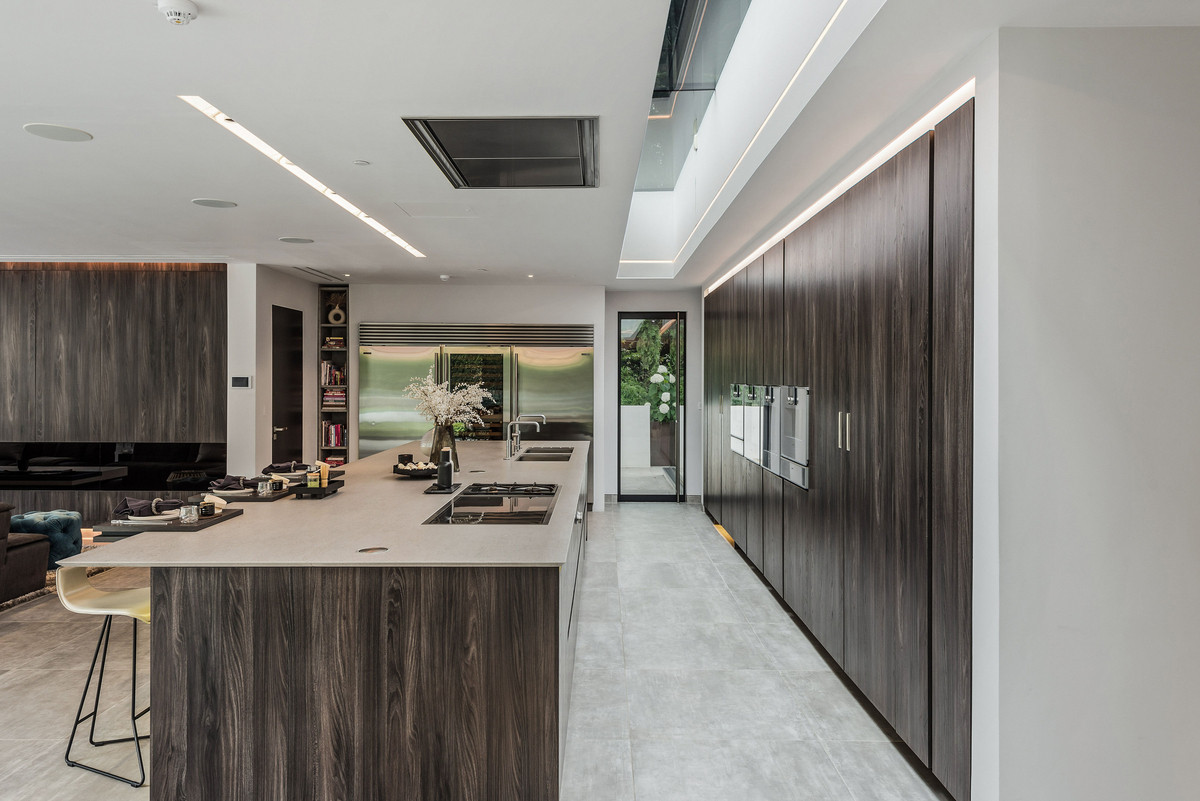 Kitchen with a big wooden island and pantry with built in appliances