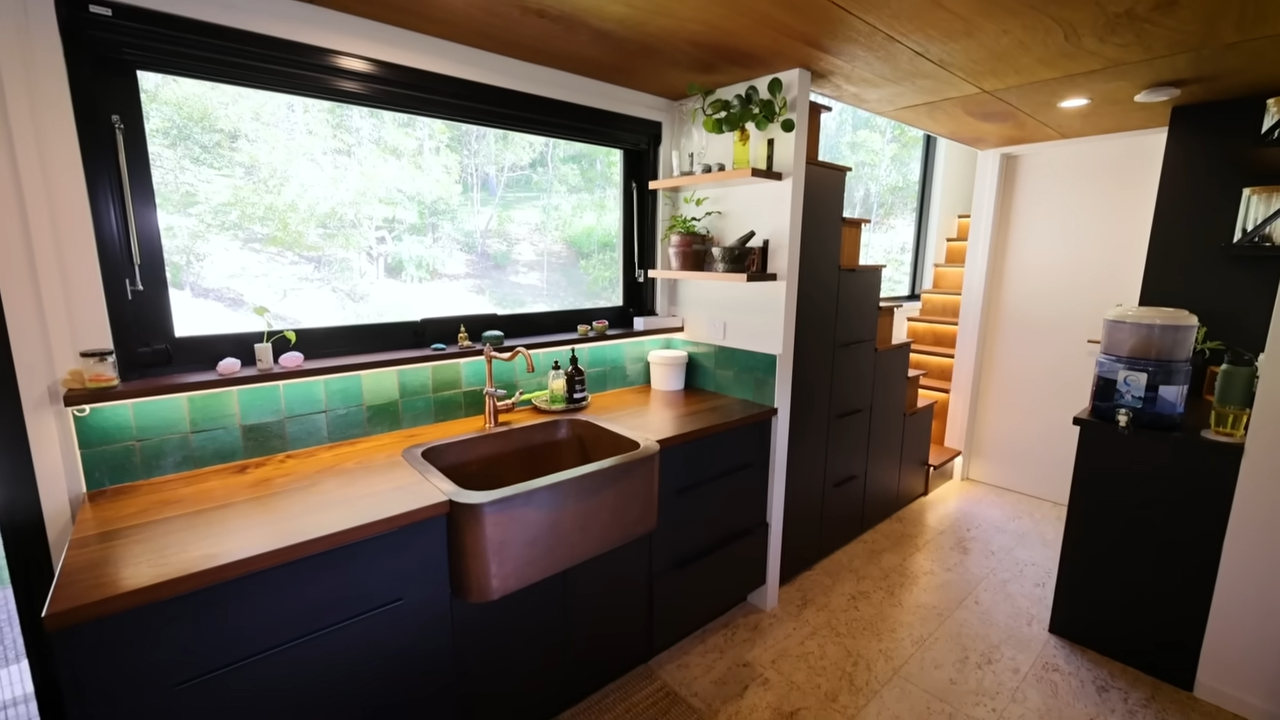 Kitchen with a copper sink, black cabinetry and a big window