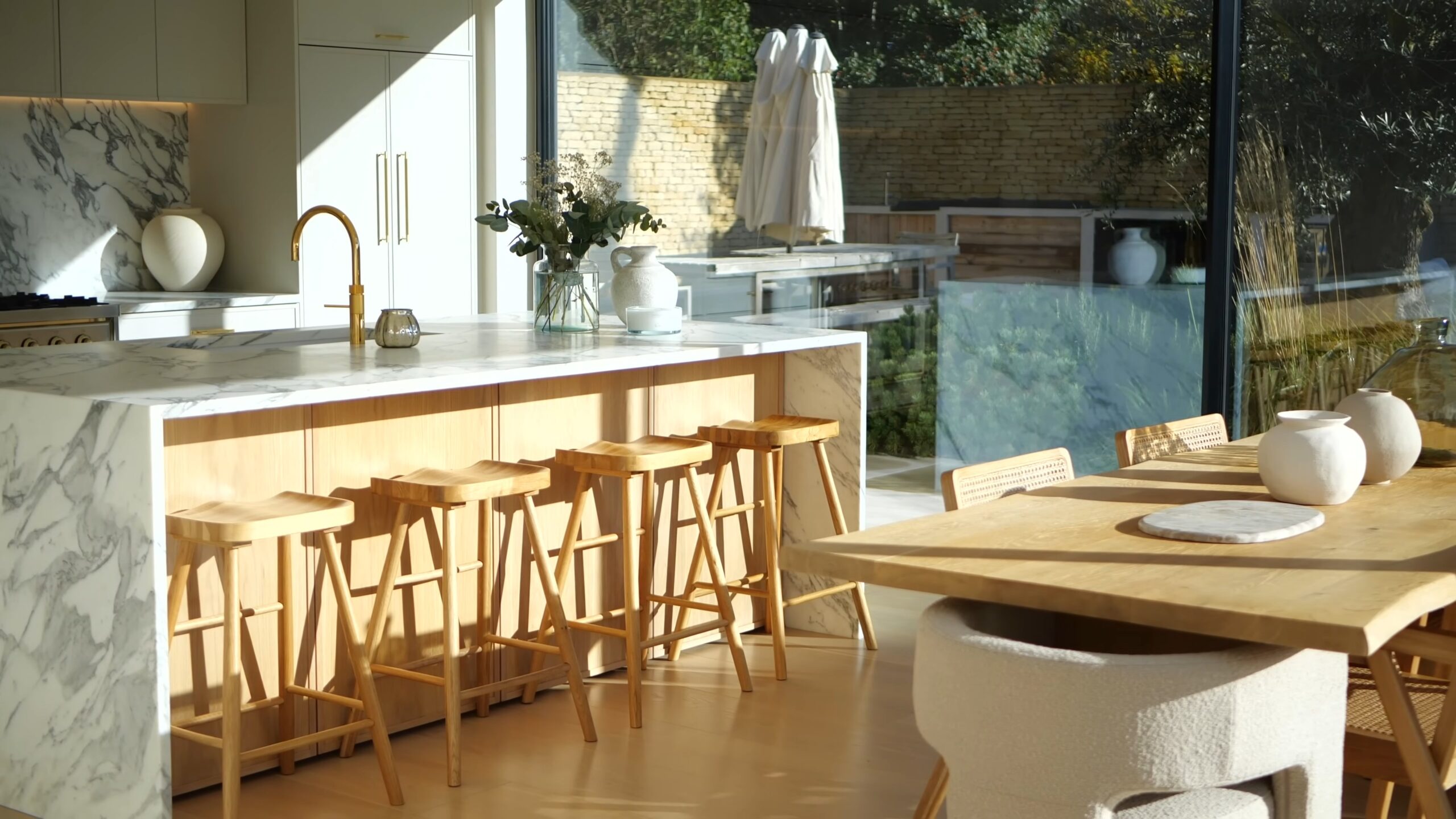 Kitchen with marble island, wooden stools and dining table