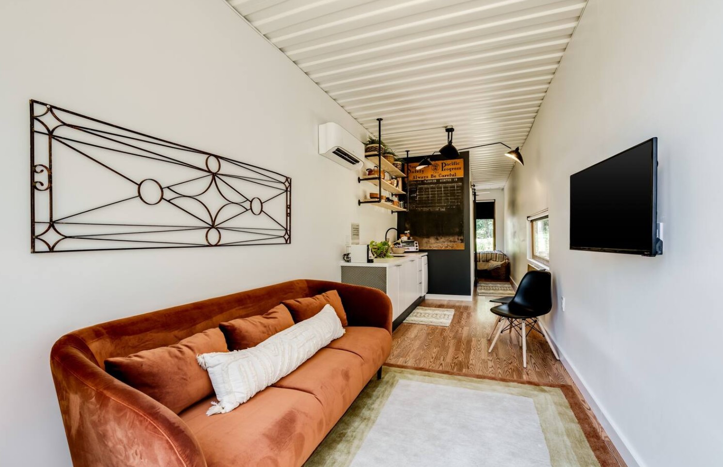 Living room with an orange couch, decorations and TV