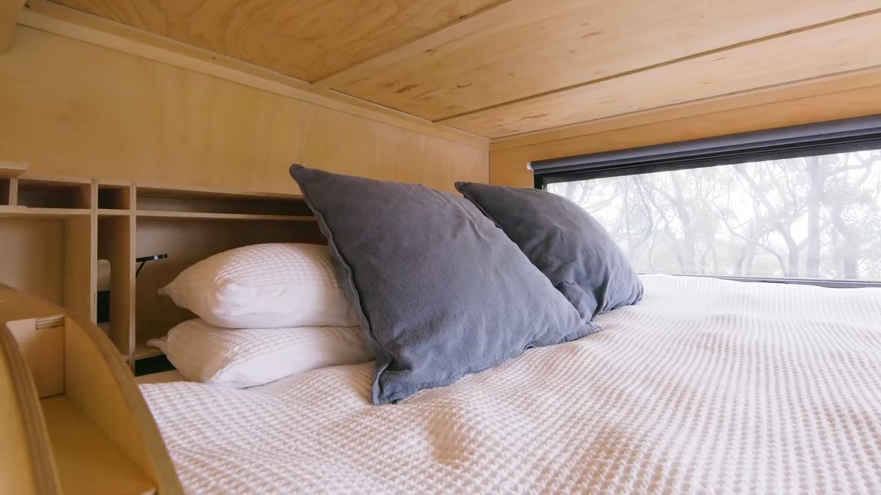 Loft with wooden shelves behind two gray pillows