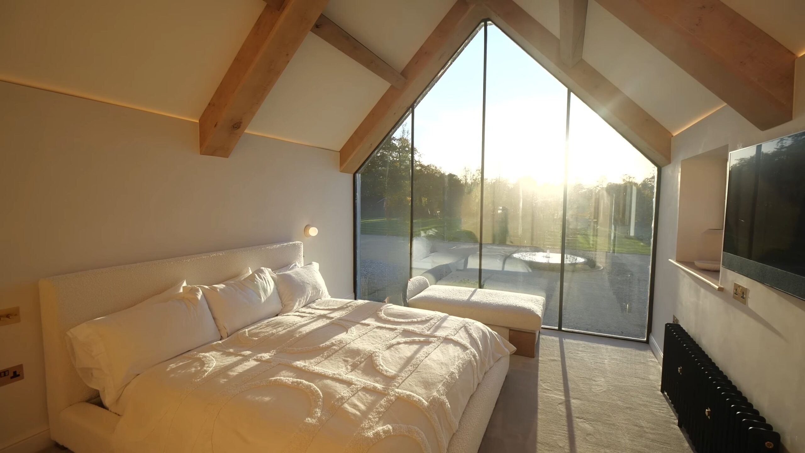 Master bedroom with glass wall and exposed beams