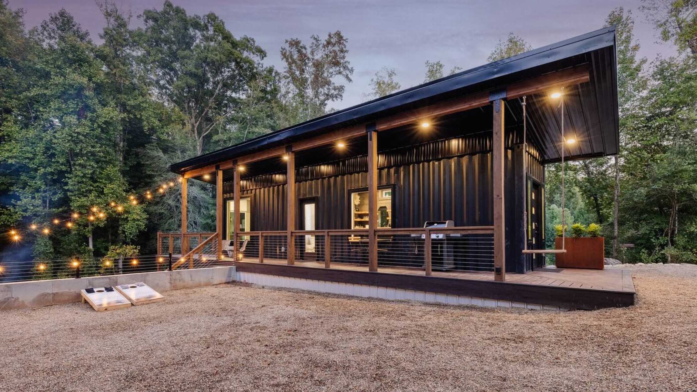 Black shipping container home with deck area