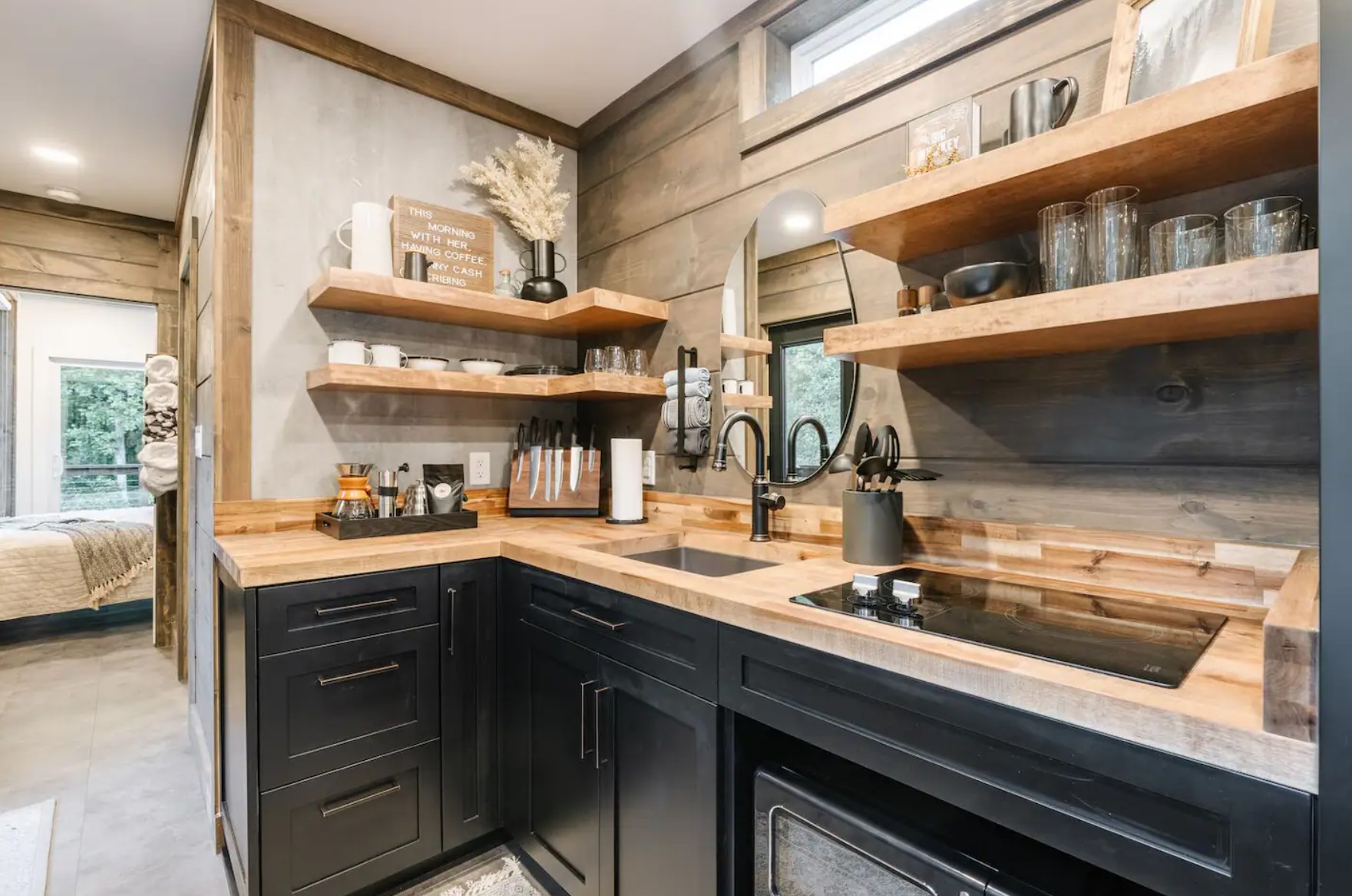 Small kitchen with black cabinets and wooden open shelves