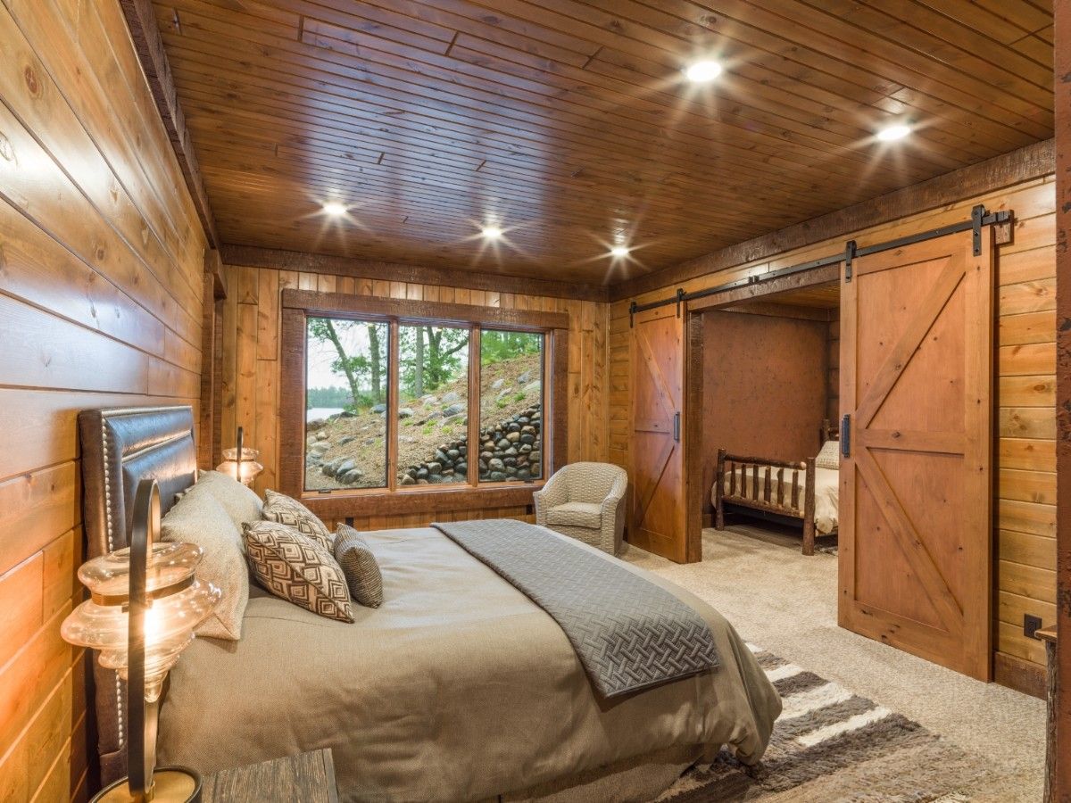 Spare wooden bedroom with windows and barn doors