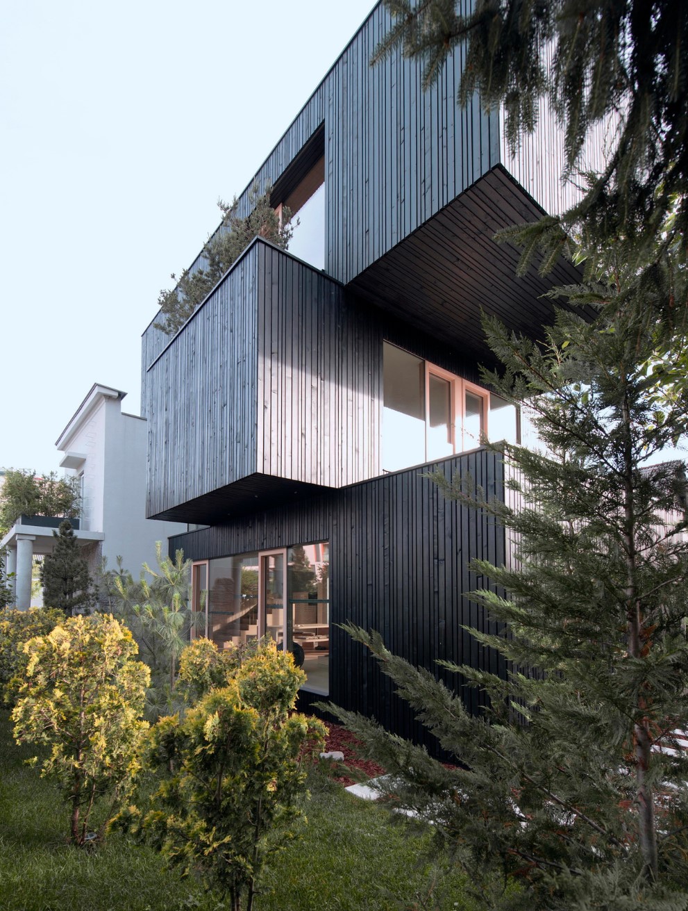 Stacked home with wooden design and huge windows