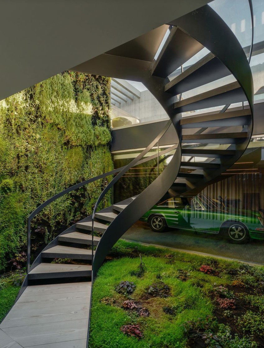 Spiral staircase with natural details and a view of the garage