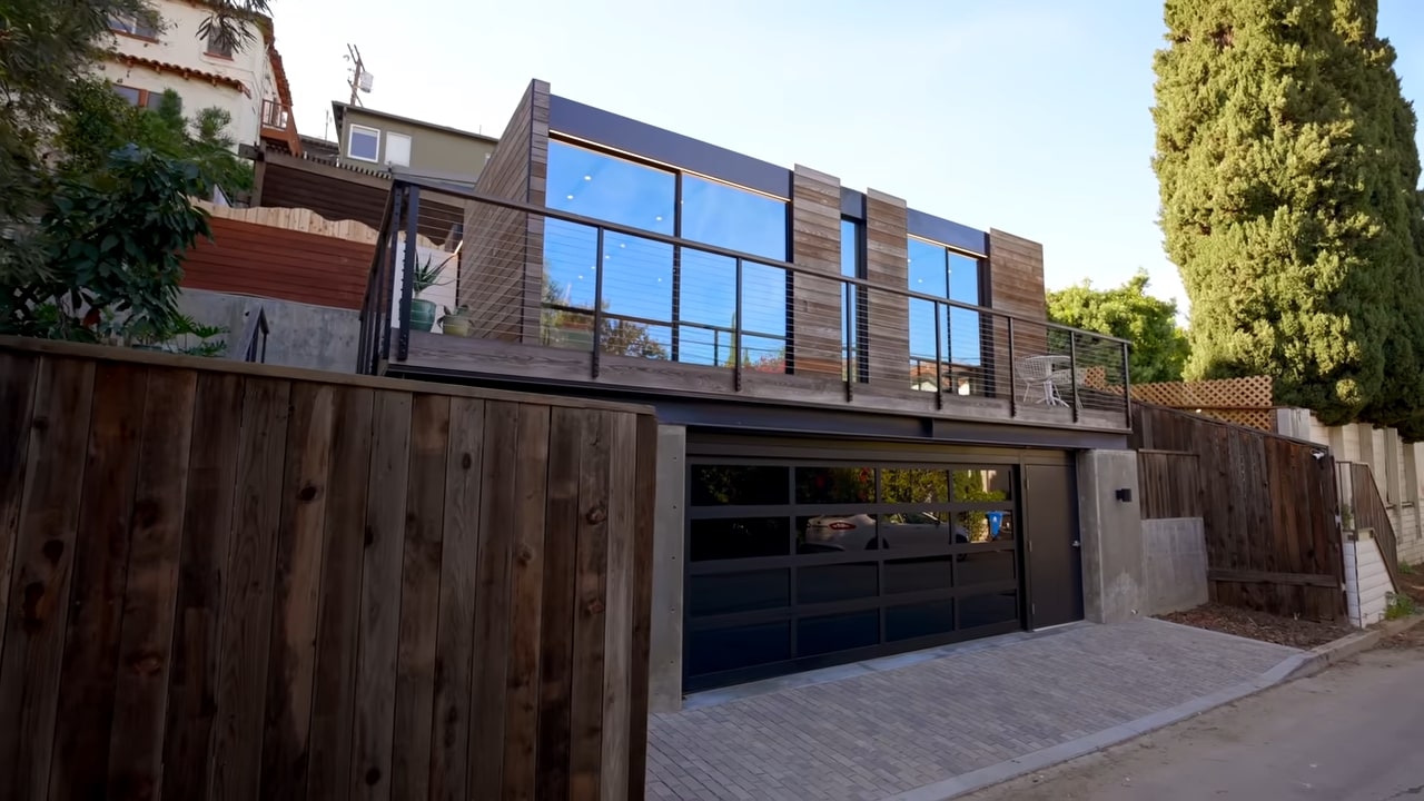 Tiny two story home with wooden exterior and garage