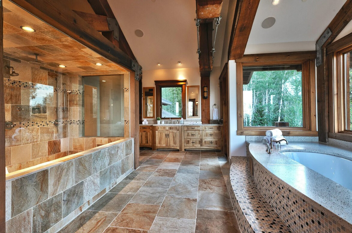 bathroom with a bathtub next to a window and a big shower