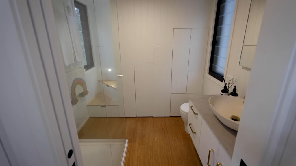 bathroom with built in cabinets, a glass shower and white cabinet