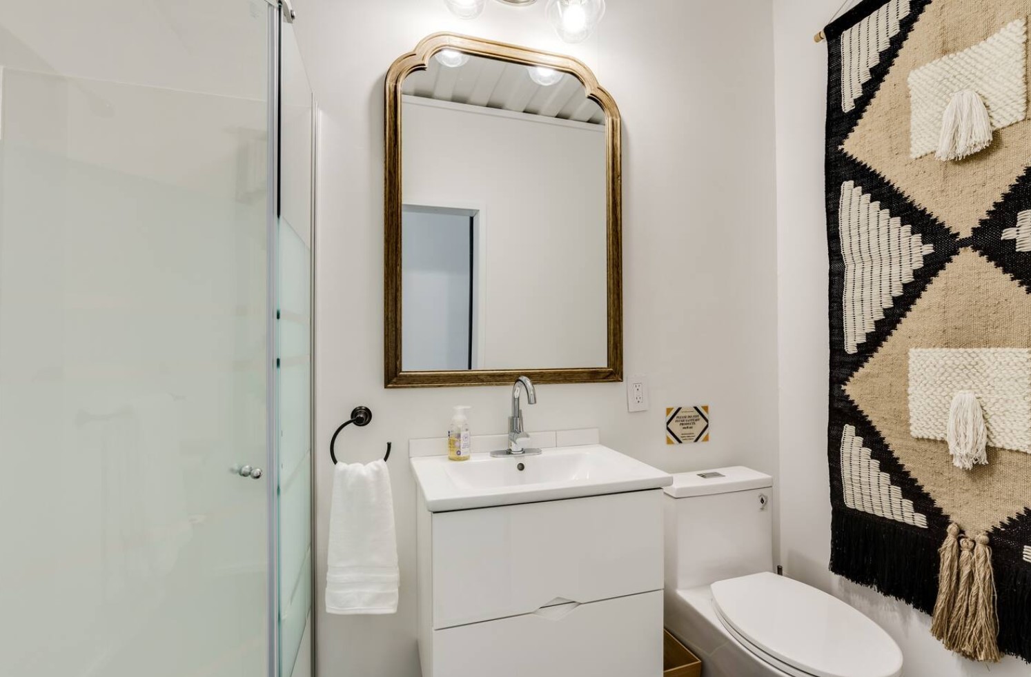 White and brown bathroom with big tapestry