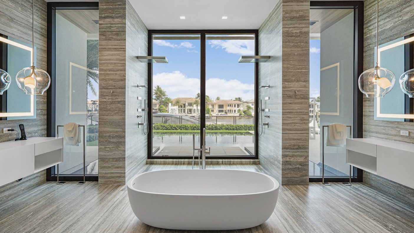 bathroom with a floor to ceiling windows and a white bathtub in the middle