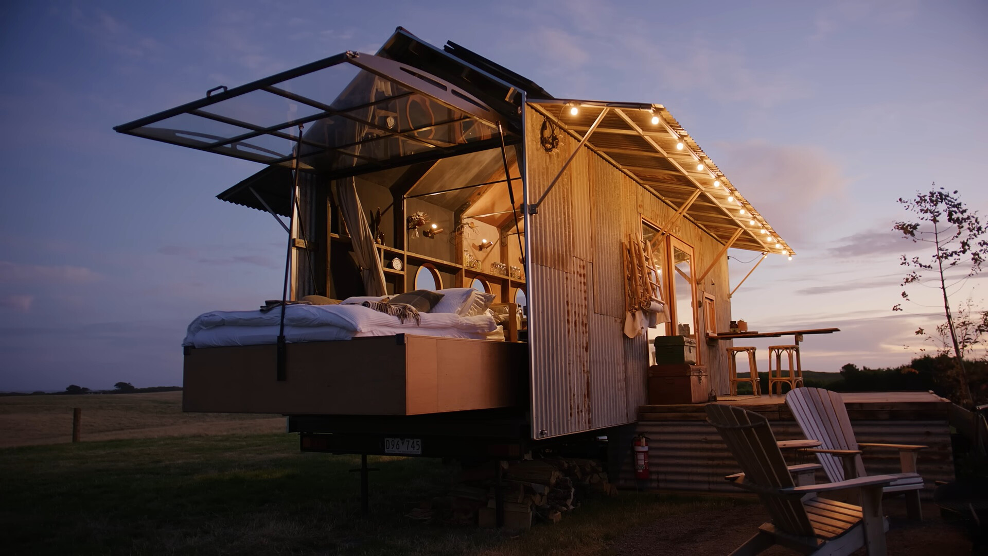 bed outside of a tiny home during a sunset