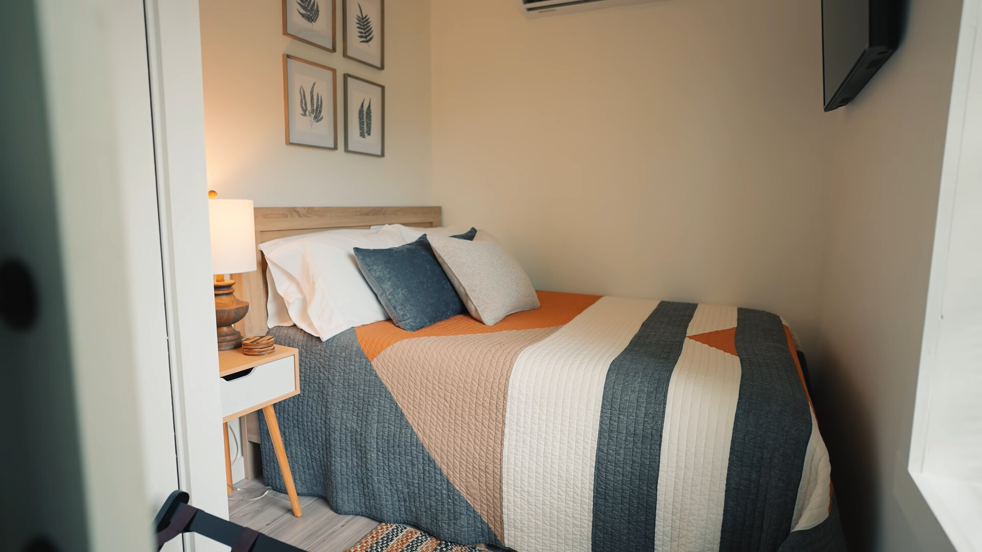 bedroom with a big, comfy bed, a flat screen tv and a bedside table with a lamp