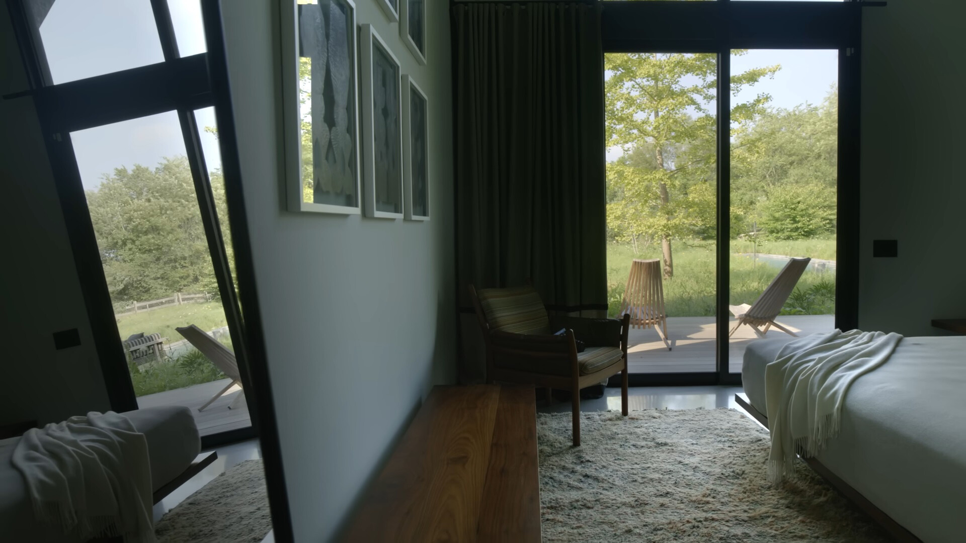 bedroom with a bed and a chair in the corner of the room and floor to ceiling windows