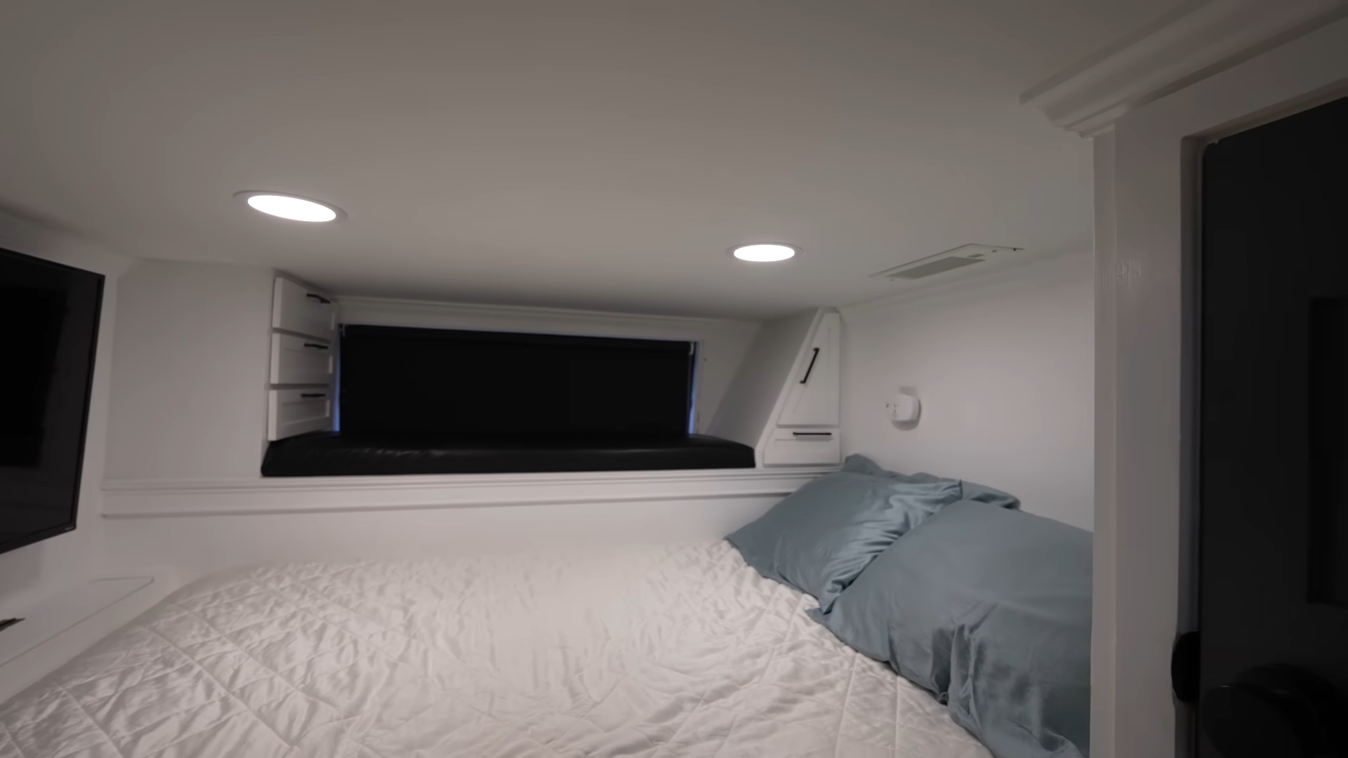 bedroom with a bed, a flat screen tv and a small window