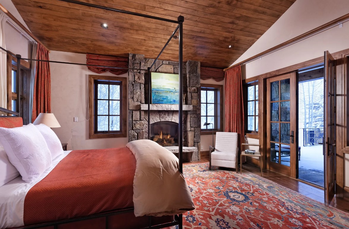 bedroom with a canopy bed, a sofa in the corner and a fireplace