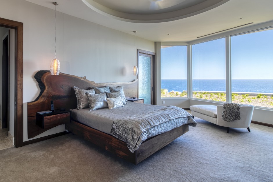 bedroom with a wooden bed frame and big windows