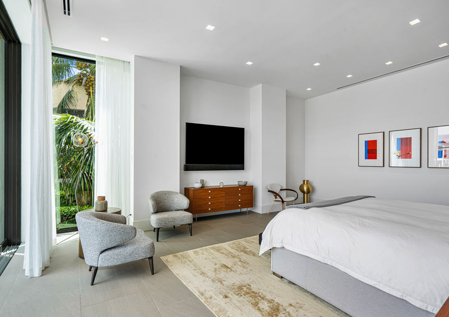 bedroom with a flat screen tv, and a brown cabinet and gray chairs