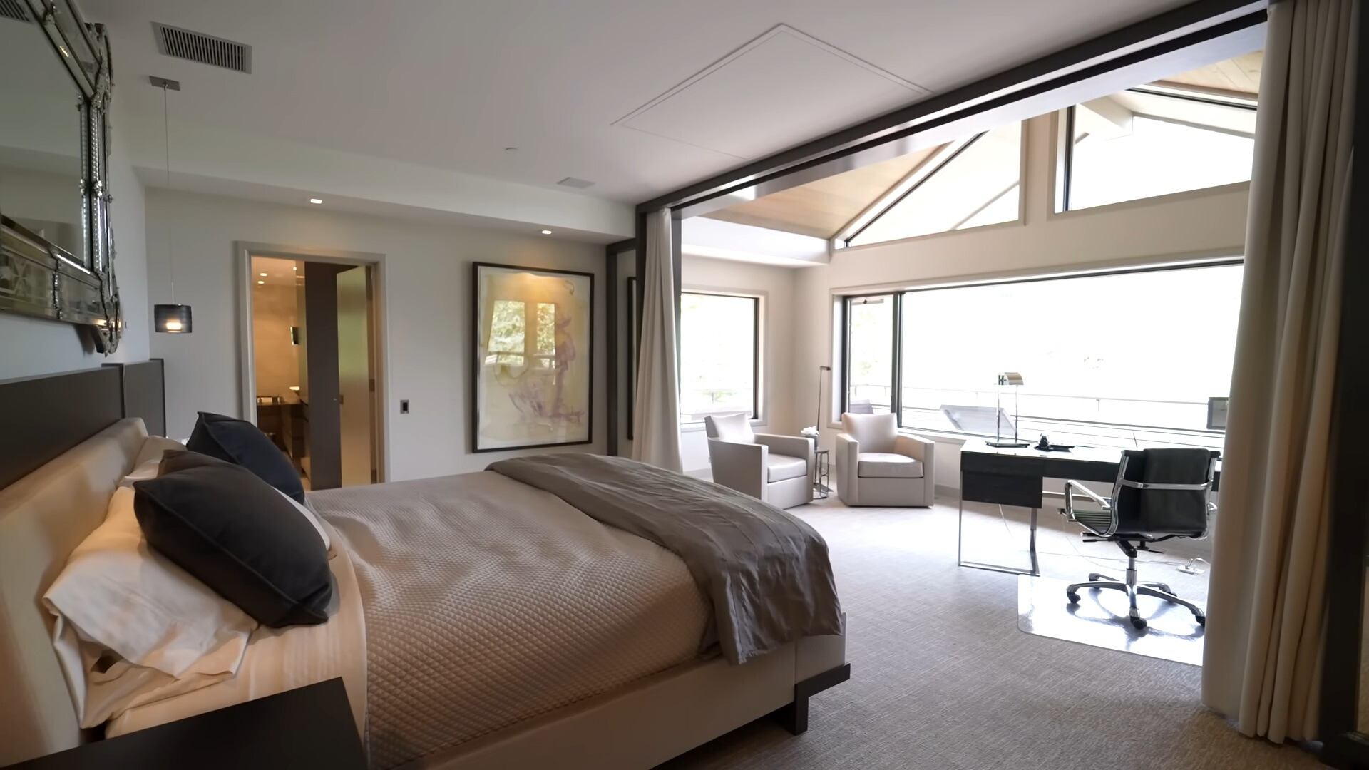 bedroom with big windows, bed in the middle and curtains on the sides