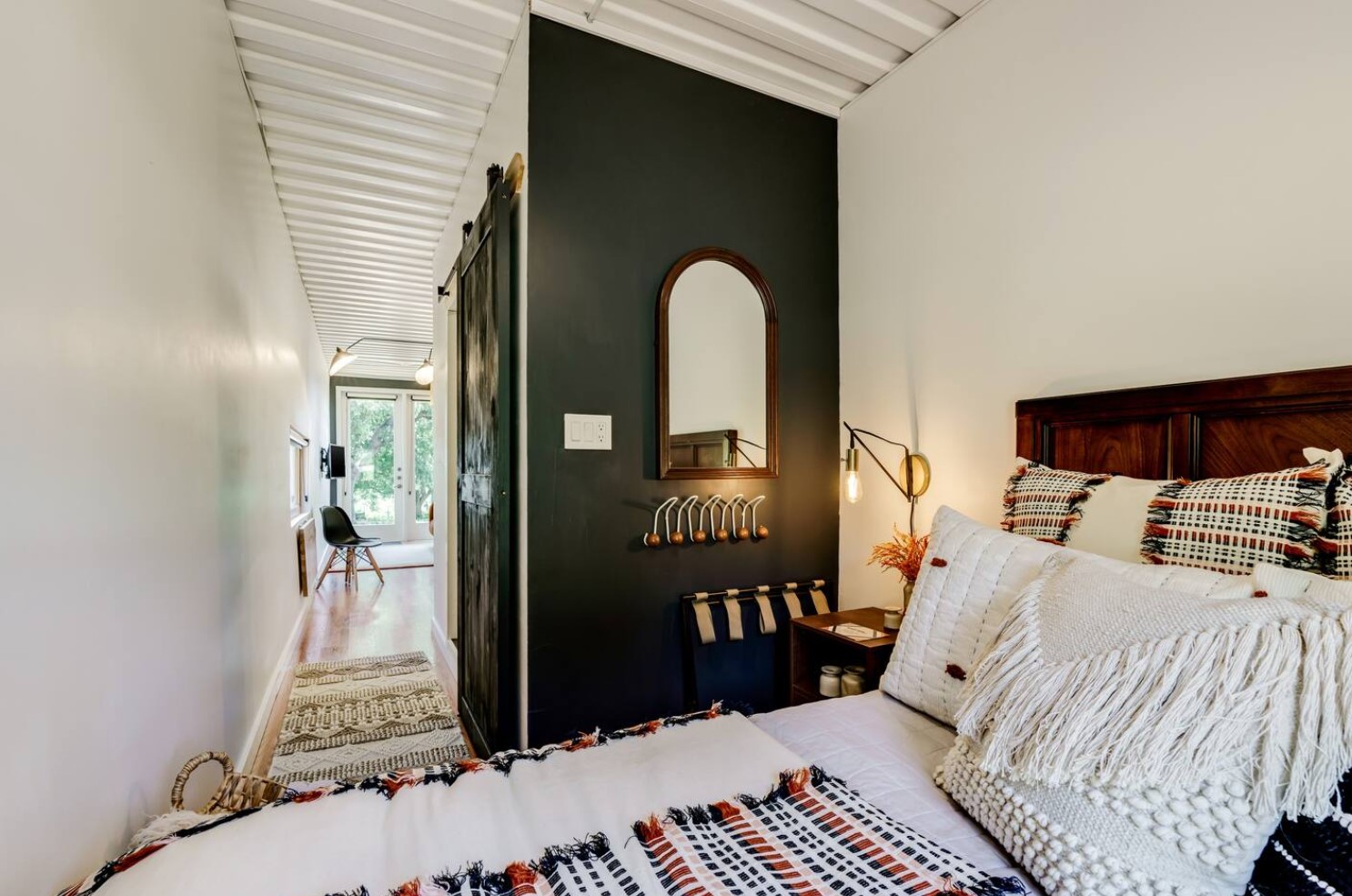 Bedroom with a black featured wall and a mirror