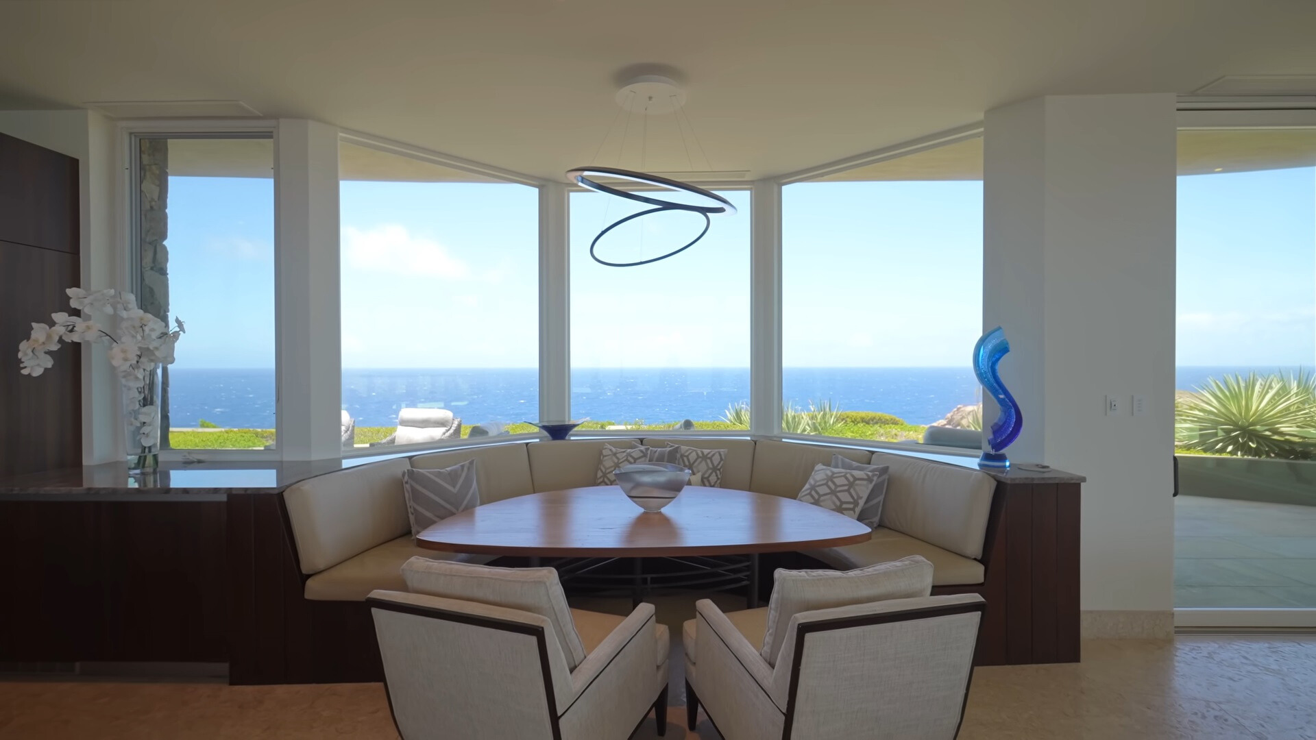 breakfast nook consisting of a built in cushioned sitting area with a brown table and big windows