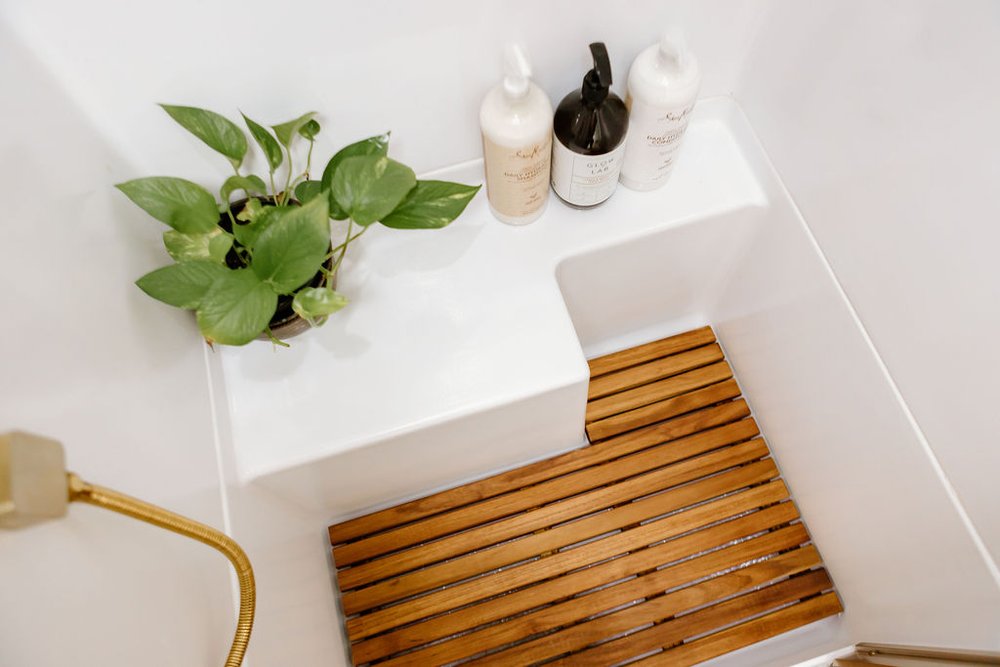 brown floor of the bathroom, potted plant and bathroom essentials