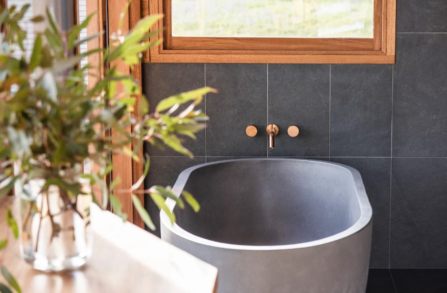 gray bathtub with dark gray tiles