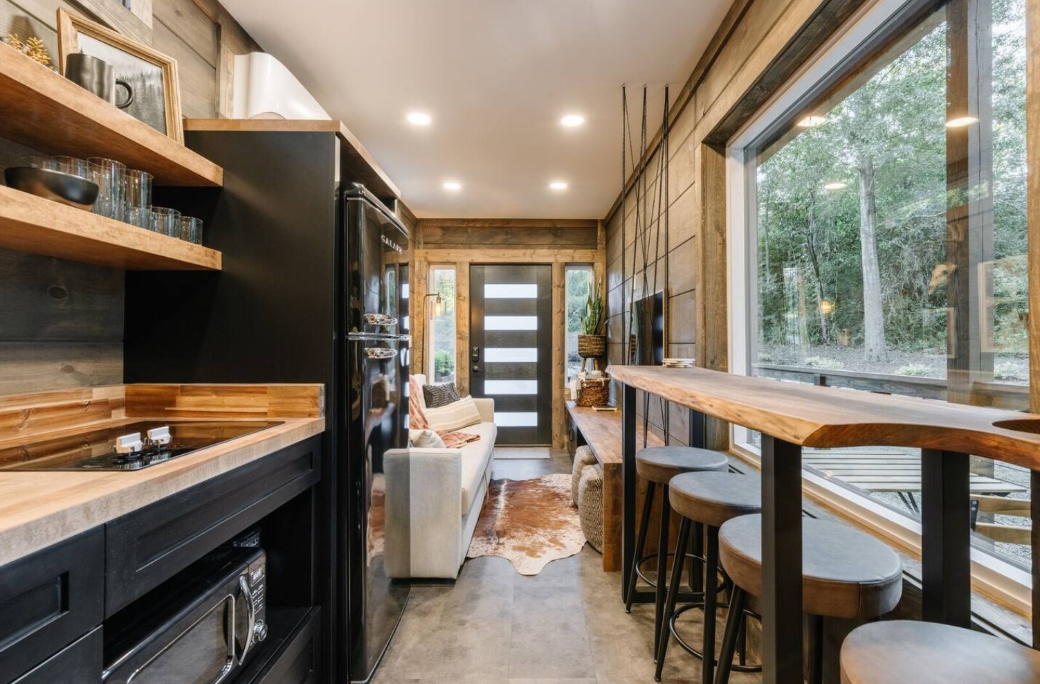 Dining area with a wooden bar table and four stools