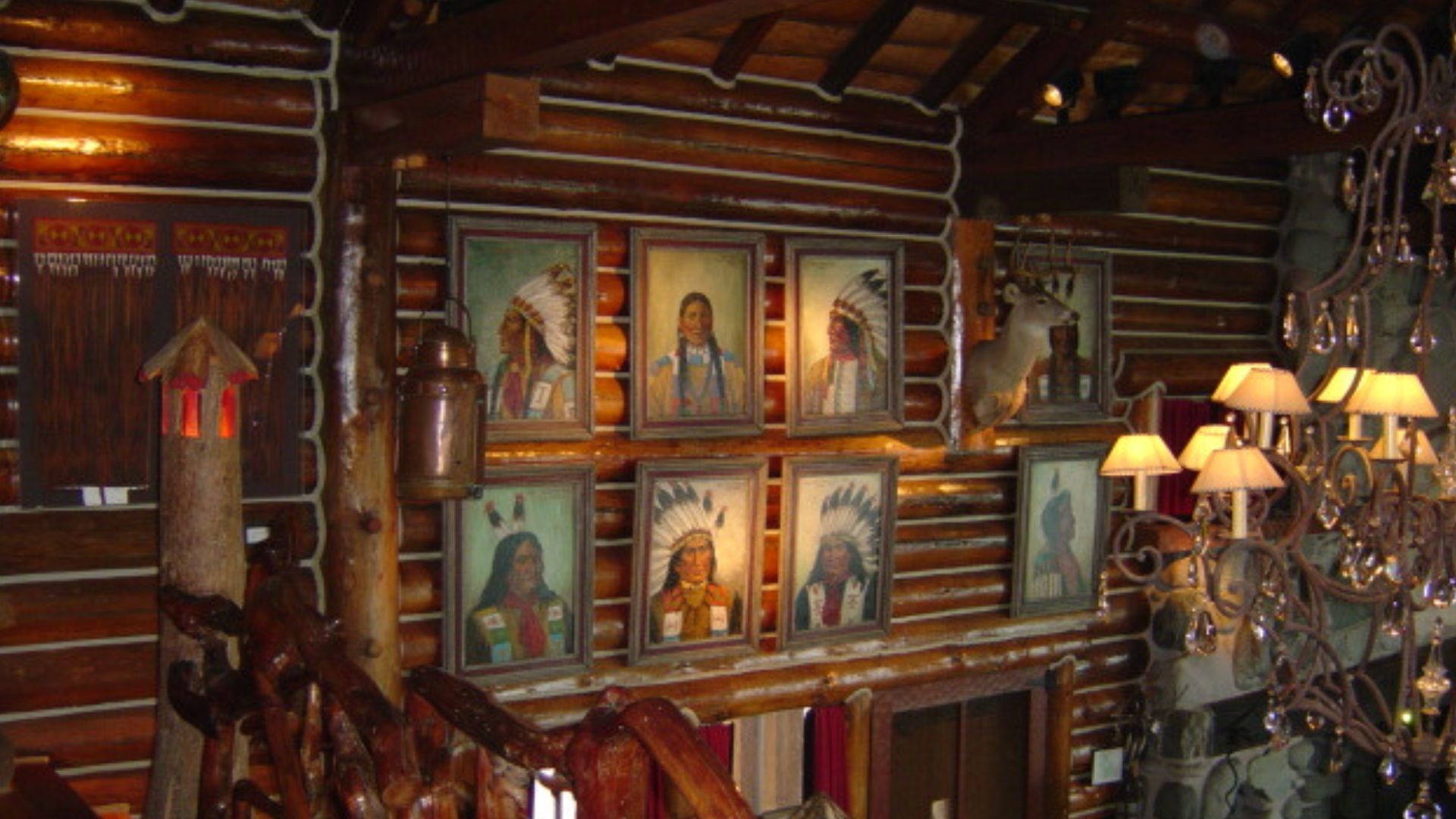 interesting wall in the great hall with painting of native americans, visible wooden handrails of the stairs