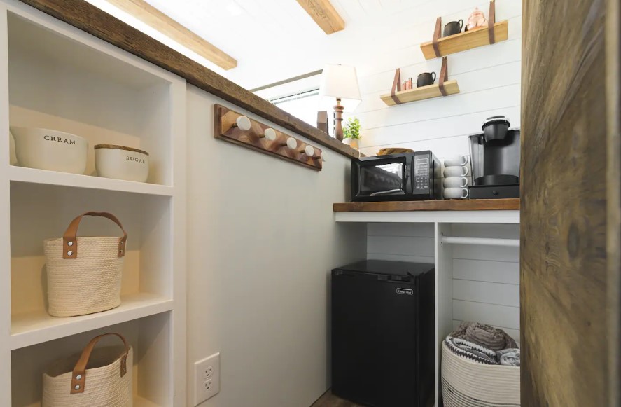 kitchen with two brown countertops, coffee machine, hanging shelves and shelves inside of the table