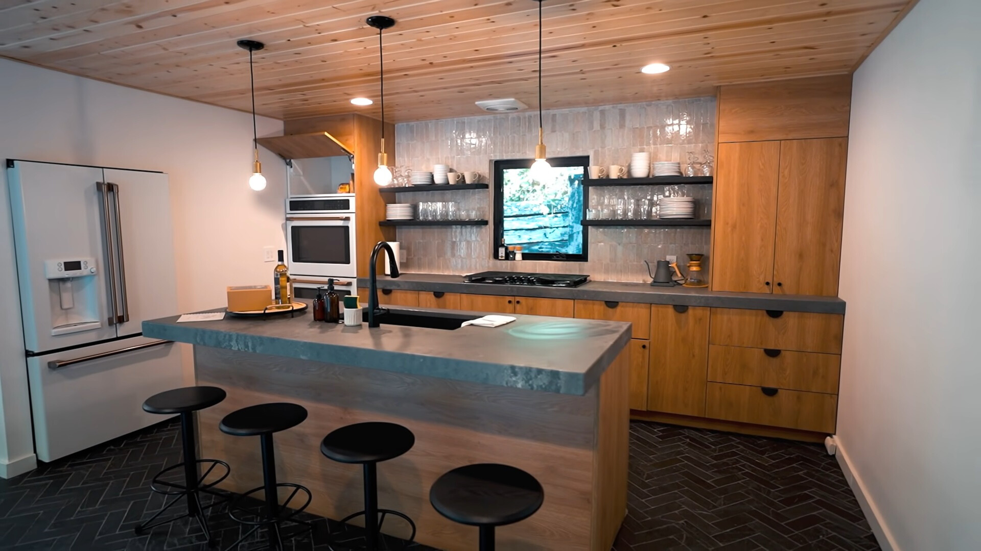 kitchen with brown cabinets and gray countertops and an island with black chairs