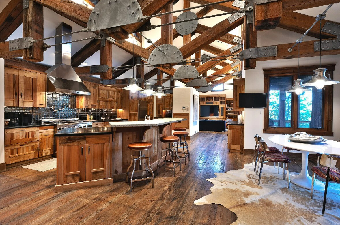 kitchen with brown cabinets and an island with bar stools and a white table on the right