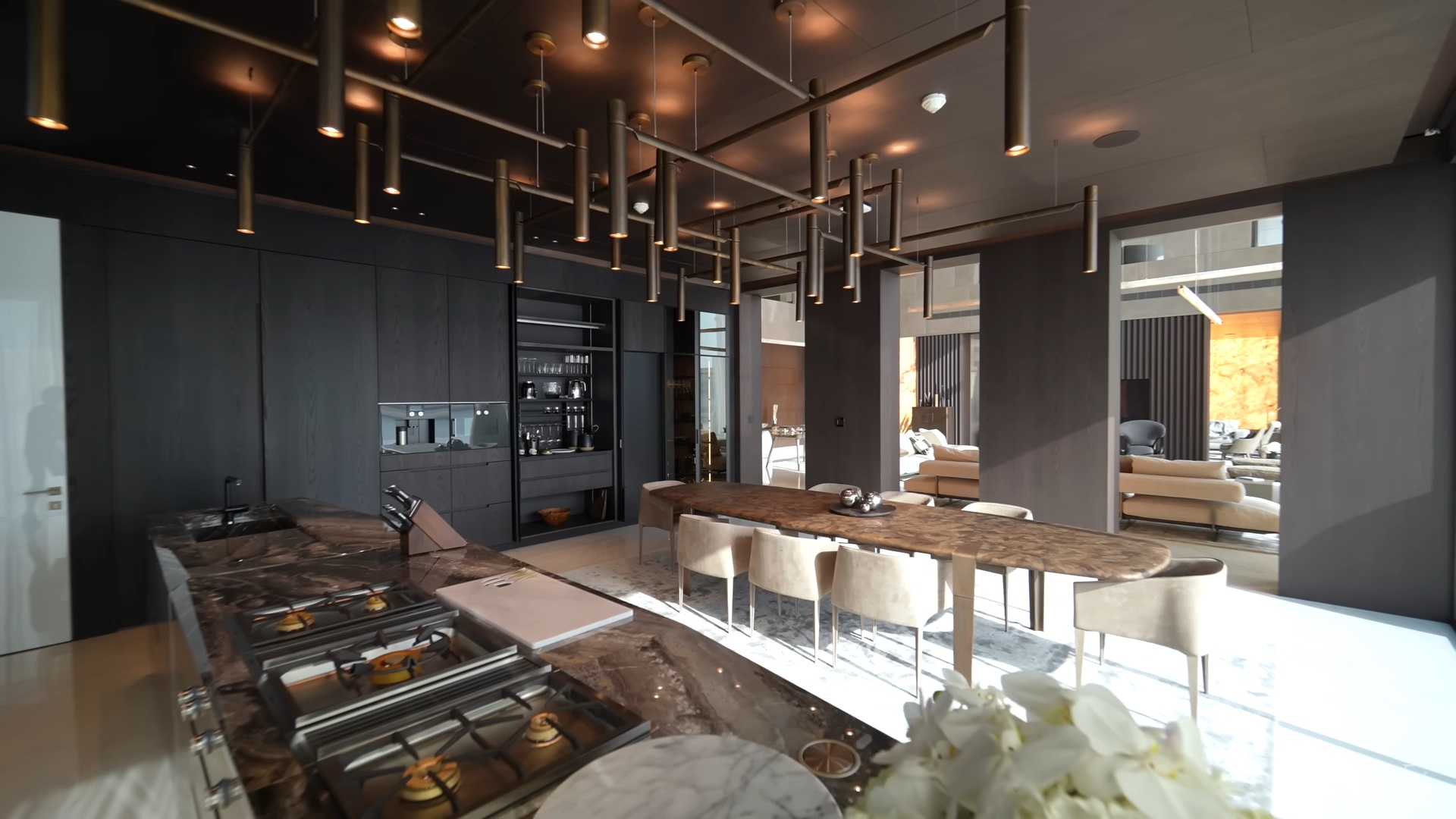 kitchen with a black cabinet, long brown dining table and white chairs