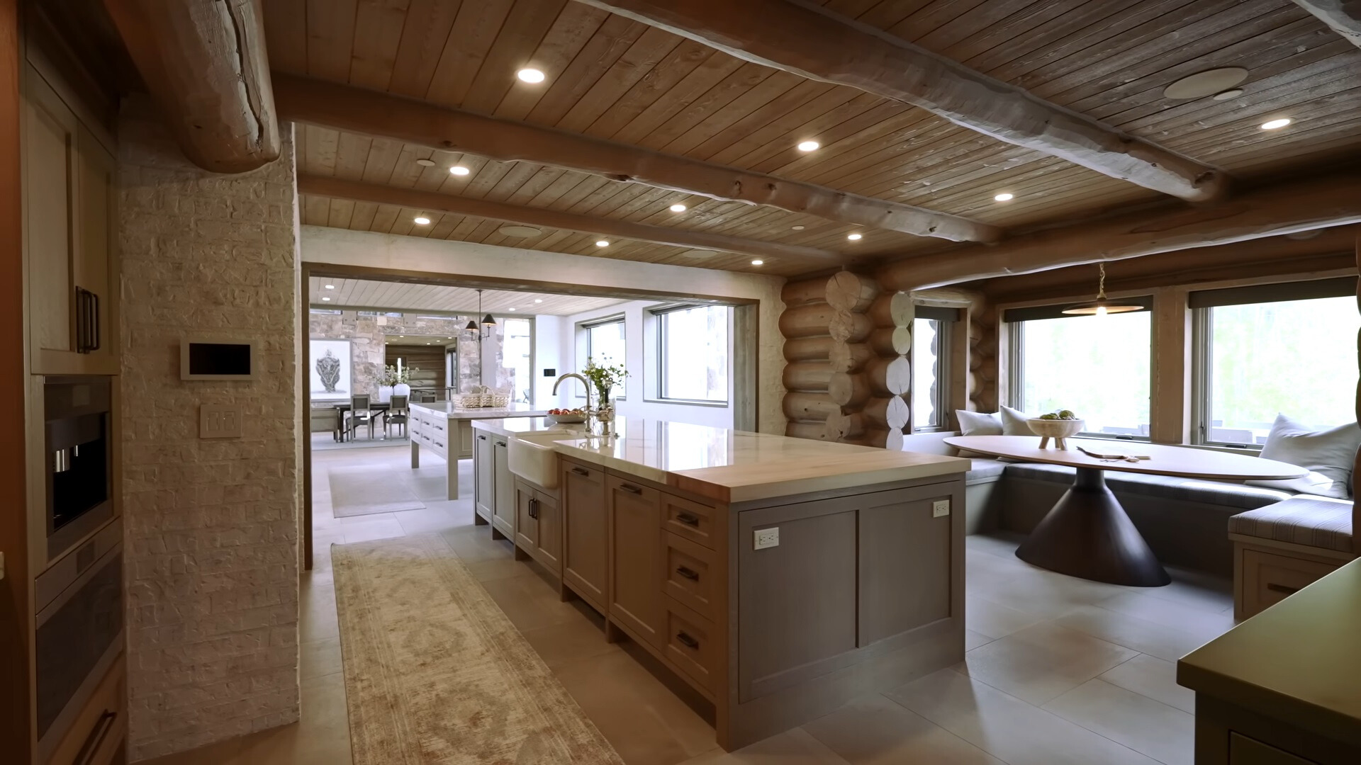 kitchen with an island with a dolomite stone countertop and a built in dining space with an oval table