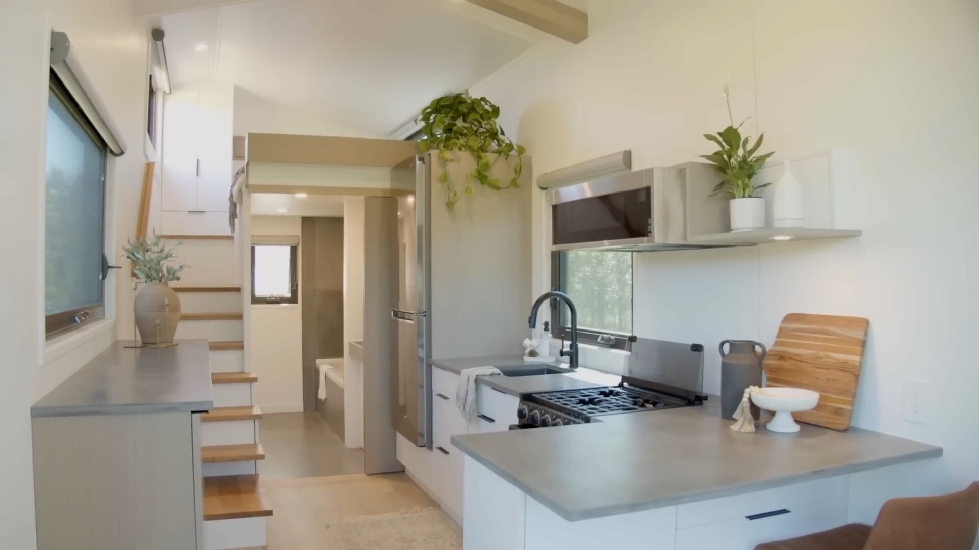 kitchen with gray countertops, white cabinets, built in table and windows