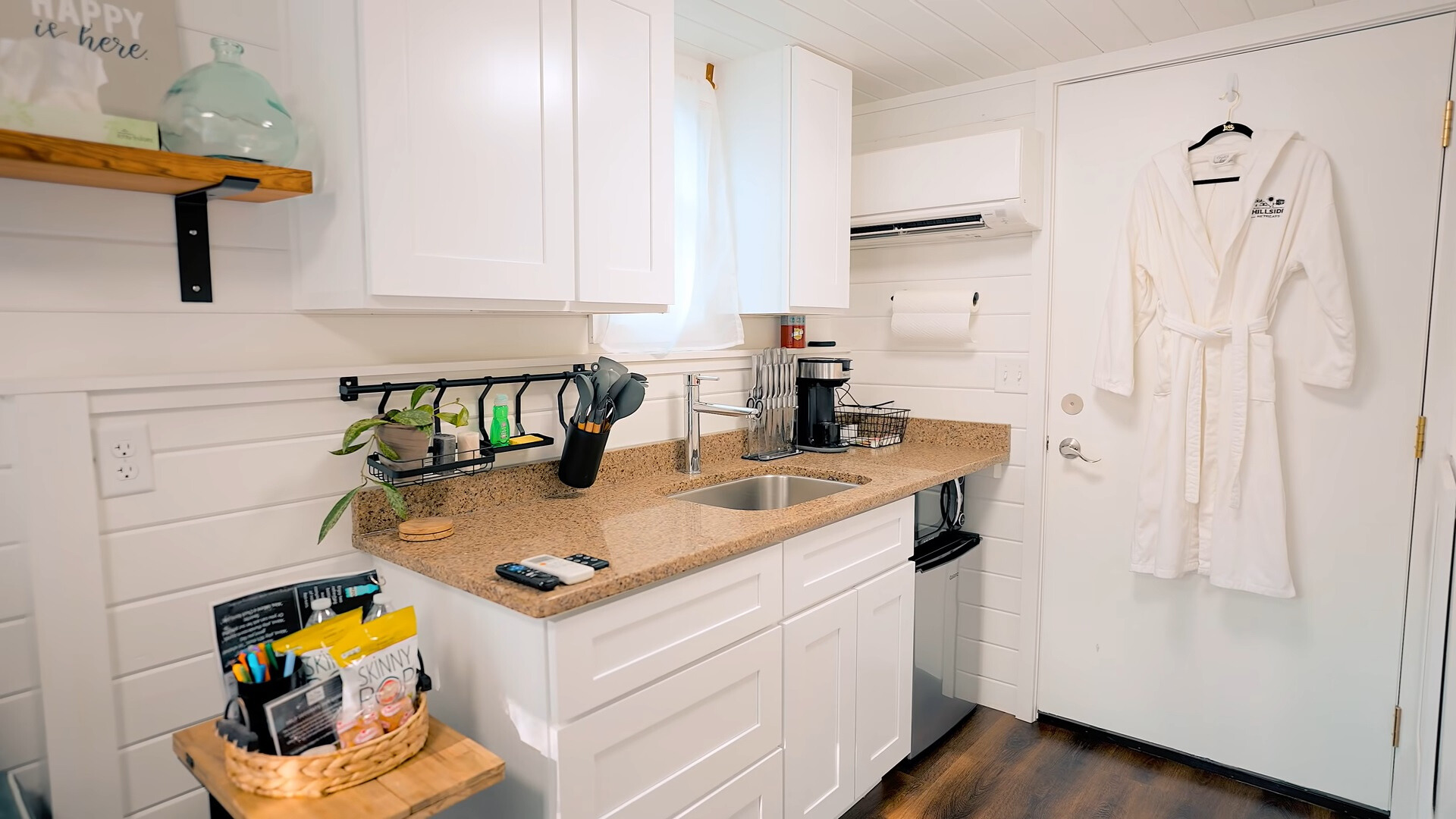 kitchen with white cabinets, brown countertop, window above the sink