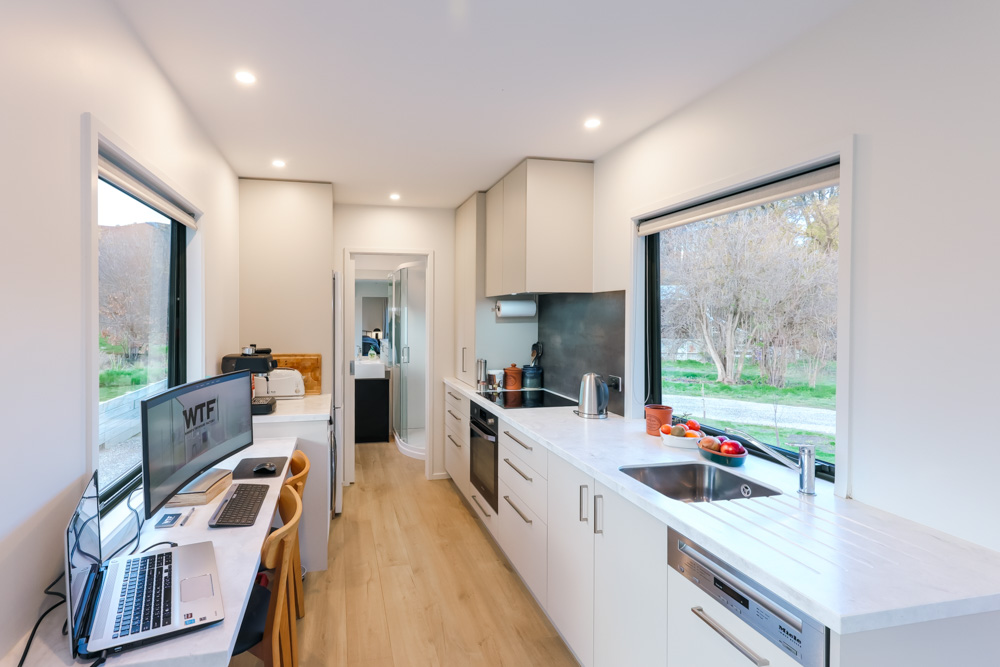 kitchen with white cabinets and white countertops and windows on both sides