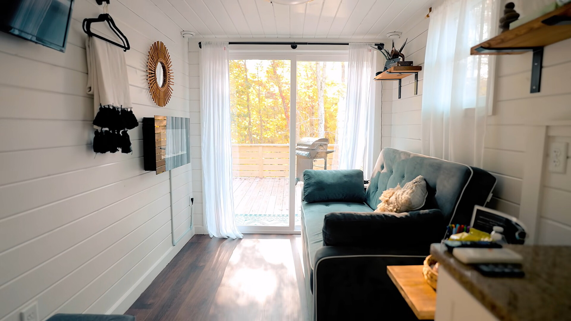 living room with a blue couch, floor to ceiling window and a flat screen tv