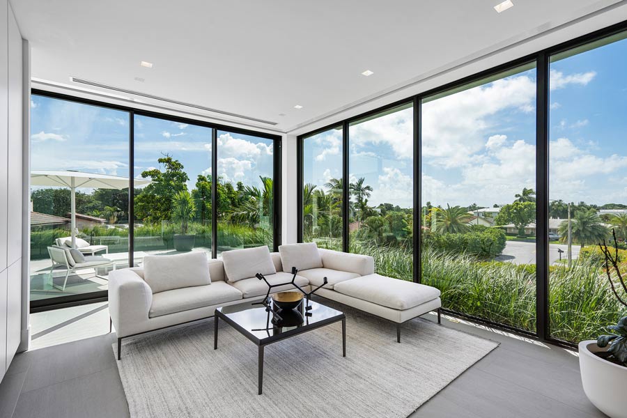 living room with an l shaped white couch, black table and a floor to ceiling window