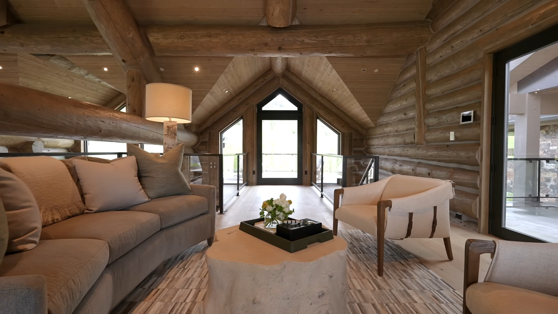 loft area of a big cabin with sitting areas and a wooden table