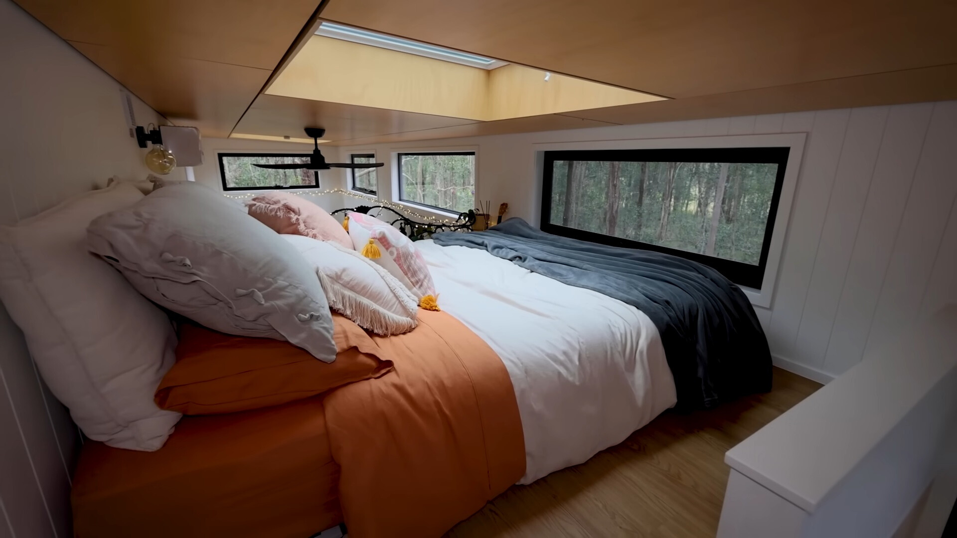 loft bedroom with windows around and a ceiling window