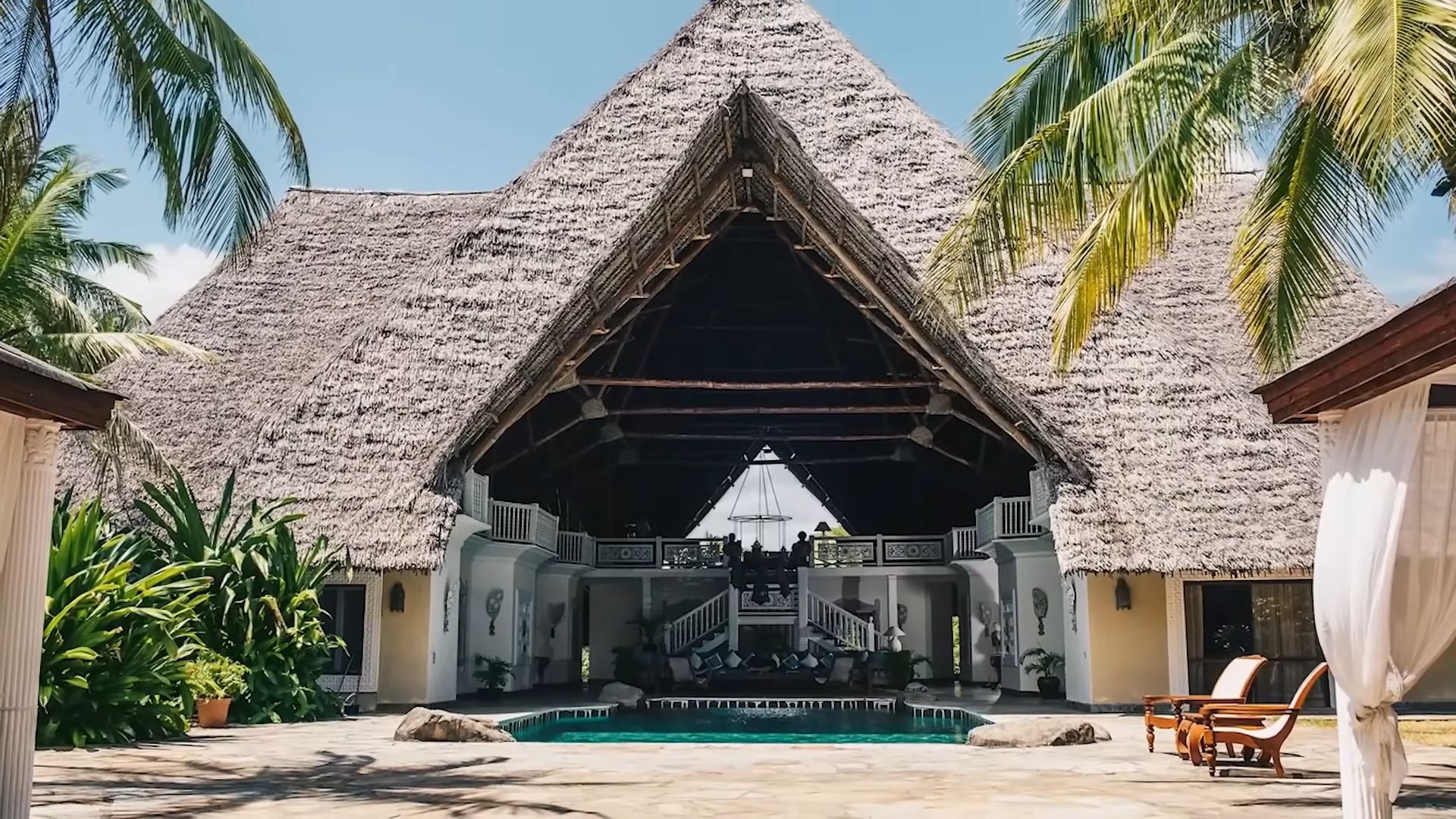 naomi campbell mansion on a tropical location, house looking like a hut, open space concept between indoors and outdoors