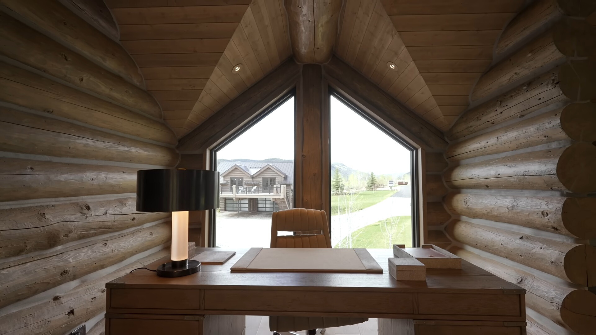 office area of a cabin with wooden walls and a wooden table