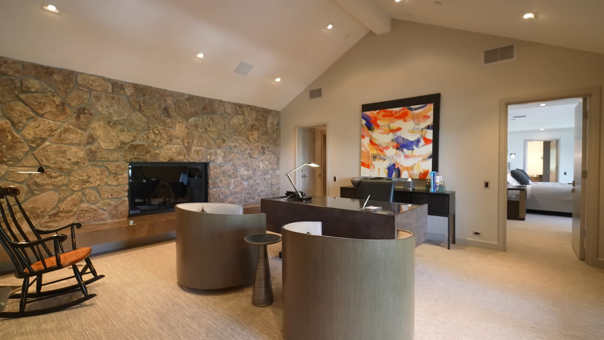 office area with a brown desk, round chairs, fireplace and a rocking chair